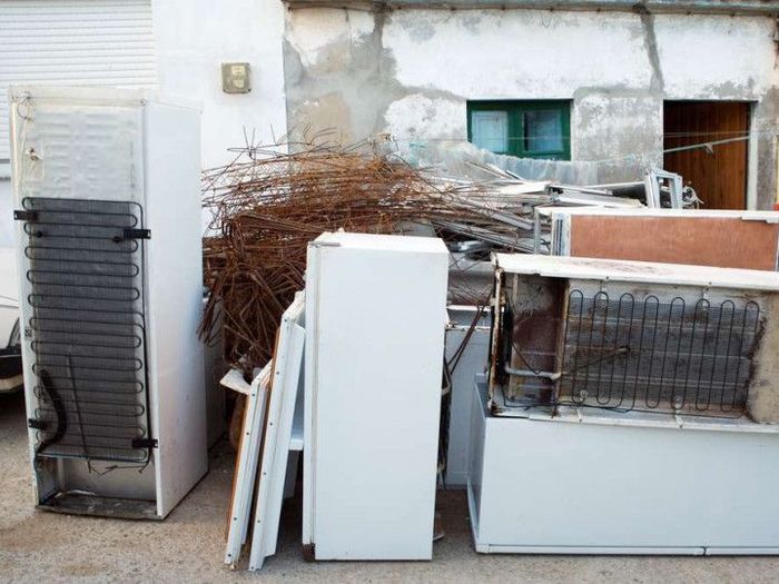 a bunch of old fridges are sitting outside of a building