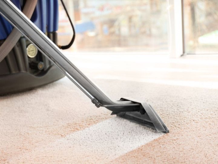 a vacuum cleaner is cleaning a carpet in a room