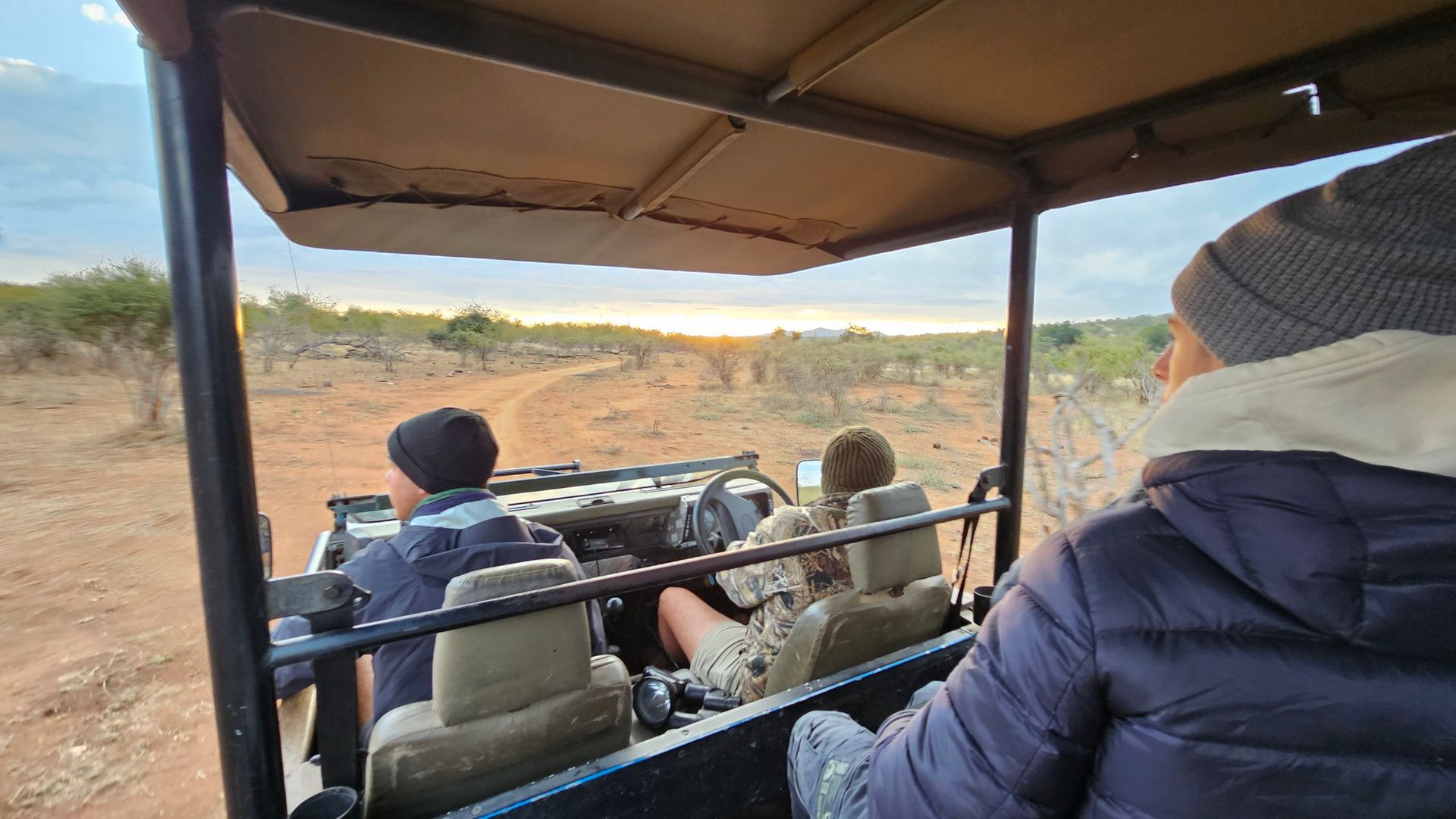 קבוצת אנשים יושבת בג'יפ על דרך עפר.