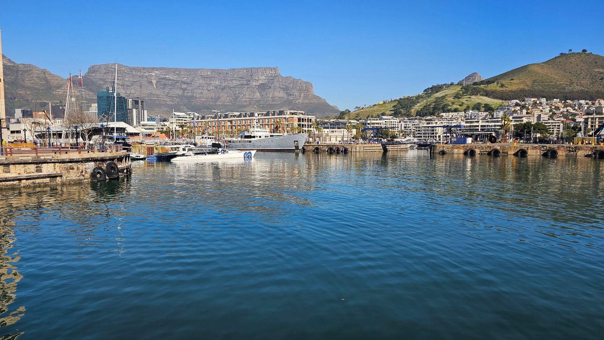 עיר משתקפת במי נמל עם הר ברקע.