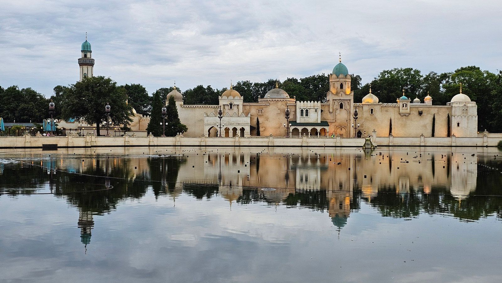 ארמון עם מים משתקפים, גוונים כחולים ובז', שמיים מעוננים.