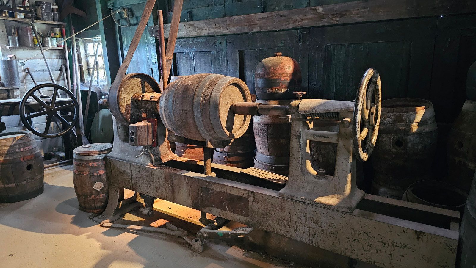 מכונת ייצור חביות עץ עתיקה בתוך סדנה פגומה.