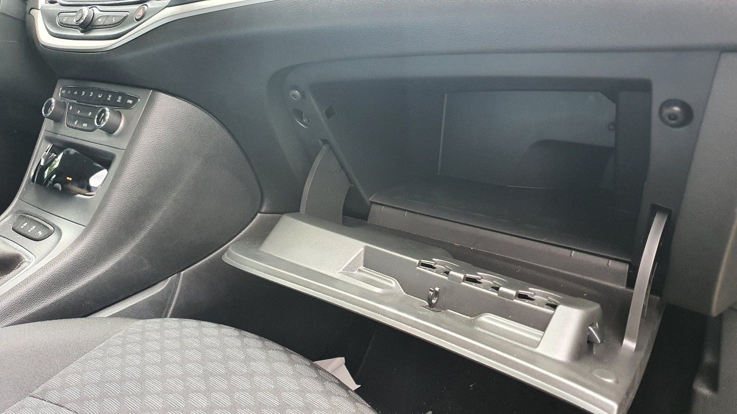 תא הכפפות של מכונית פתוח וריק.