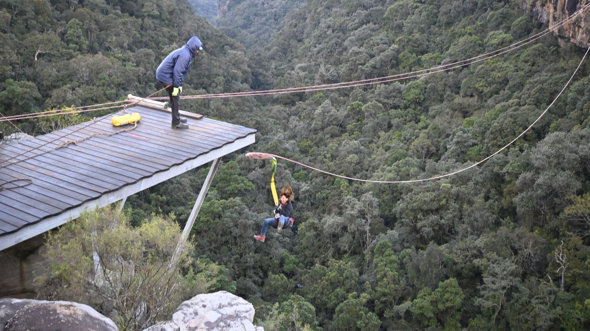 גבר עומד על גג בניין המשקיף על יער.