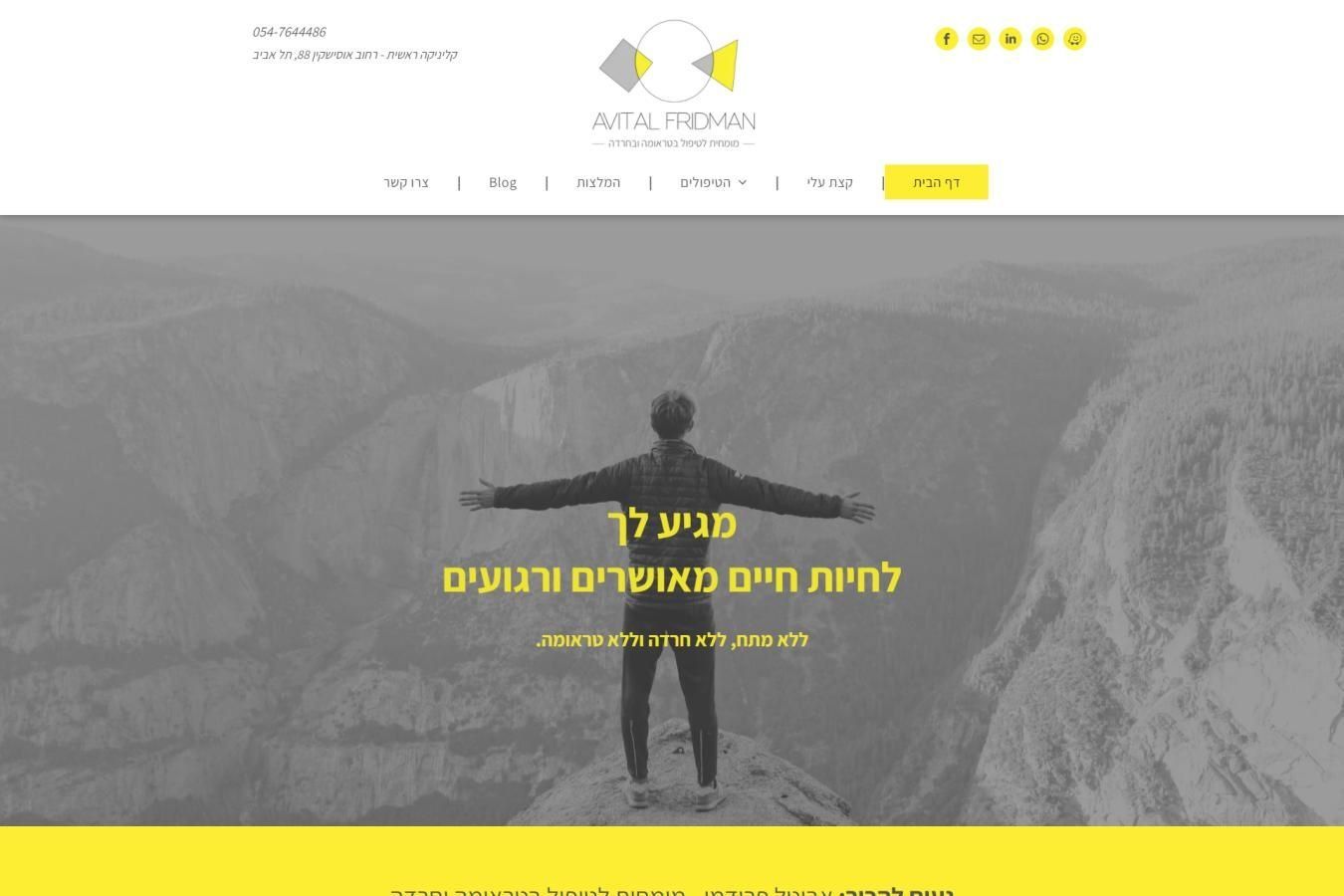 אדם עומד על ראש הר עם זרועותיו פרושות.