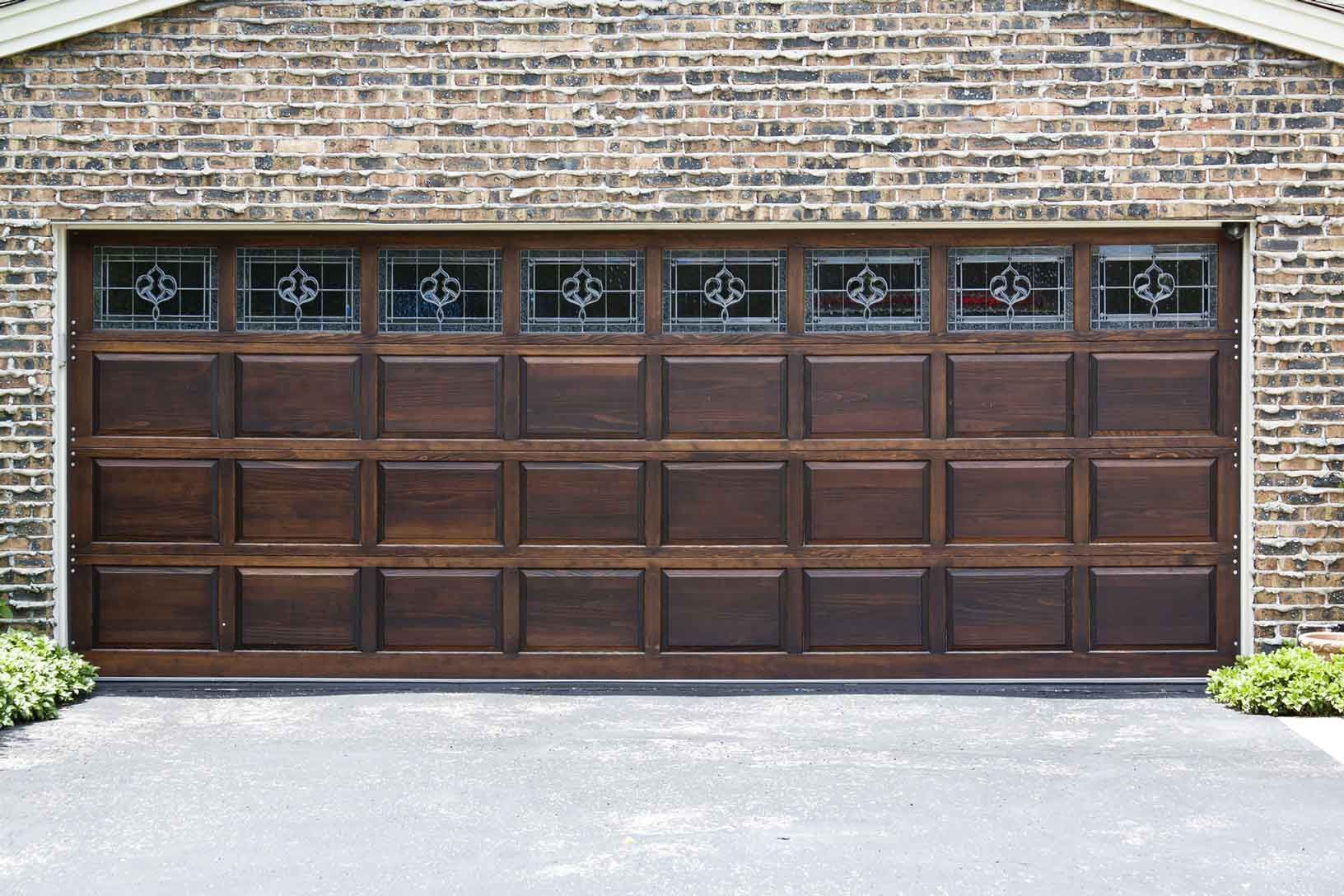 A large wooden garage door with stained glass windows
