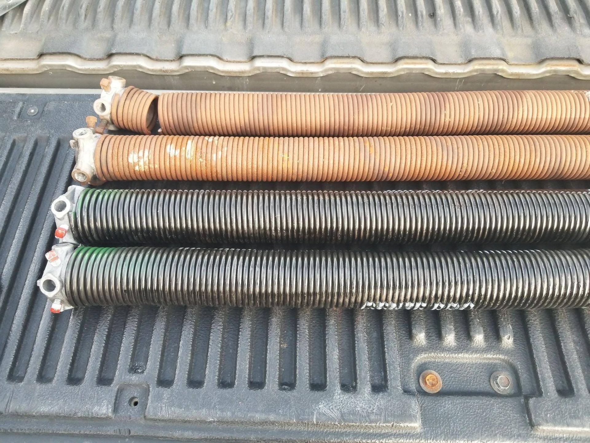 A bunch of garage door springs are sitting in the back of a truck.