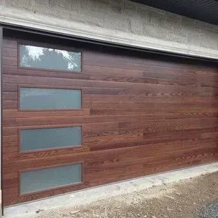A wooden garage door with frosted glass windows on a concrete wall.