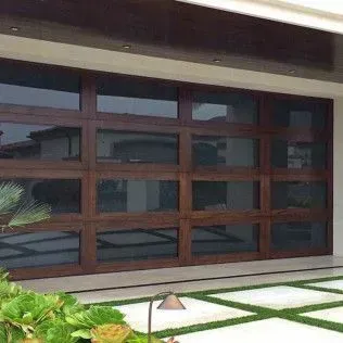 A large wooden garage door with a lot of windows is in front of a house.
