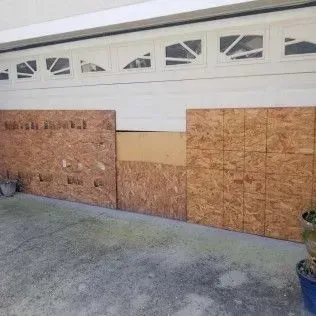 A garage door with a lot of plywood on it.