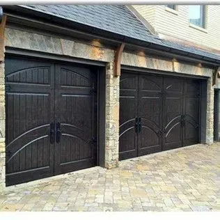 A row of wooden garage doors on a brick building.