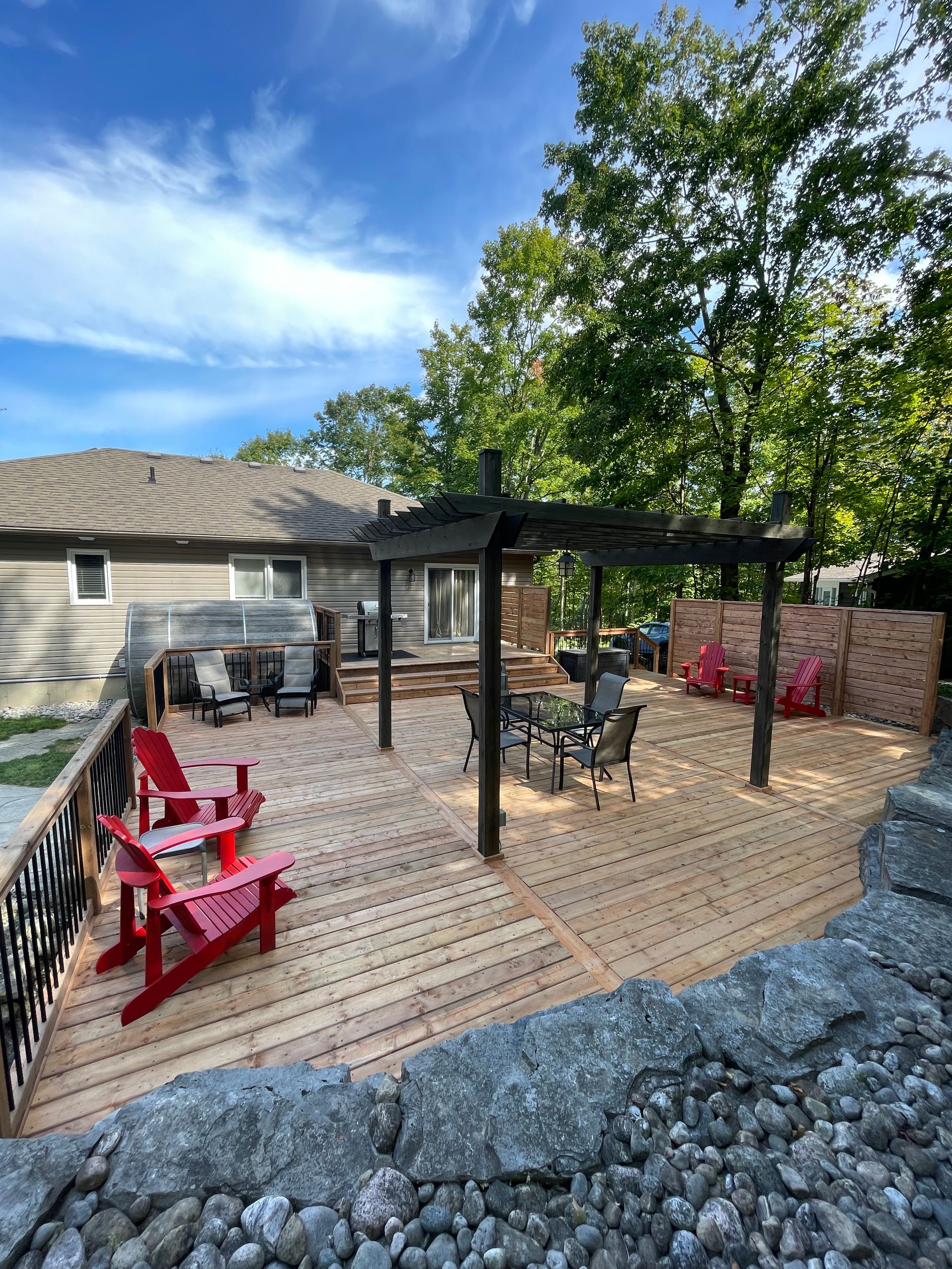 backyard deck with a pergola and lounge chairs
