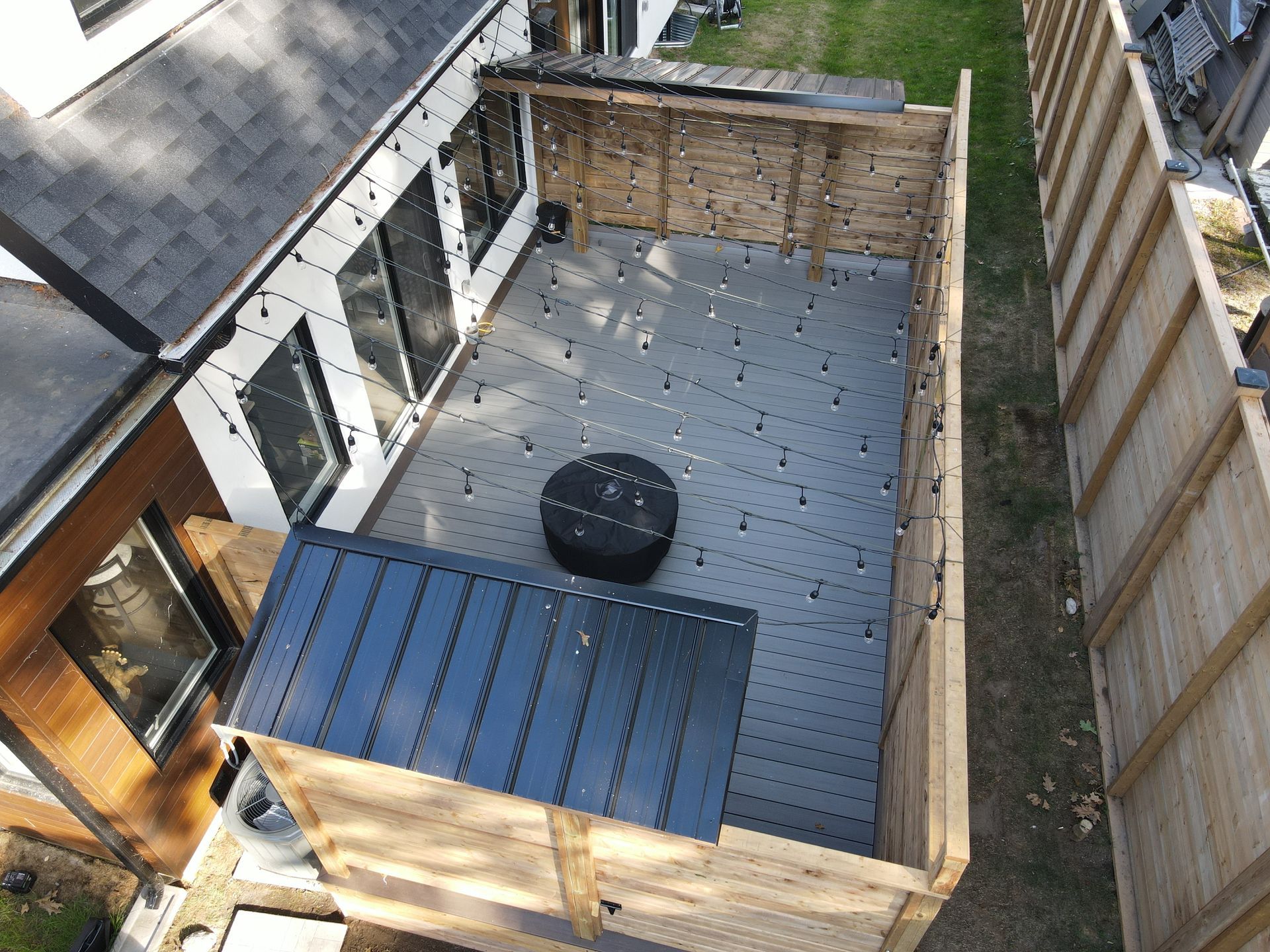 An aerial view of a backyard with a wooden deck and a fence.