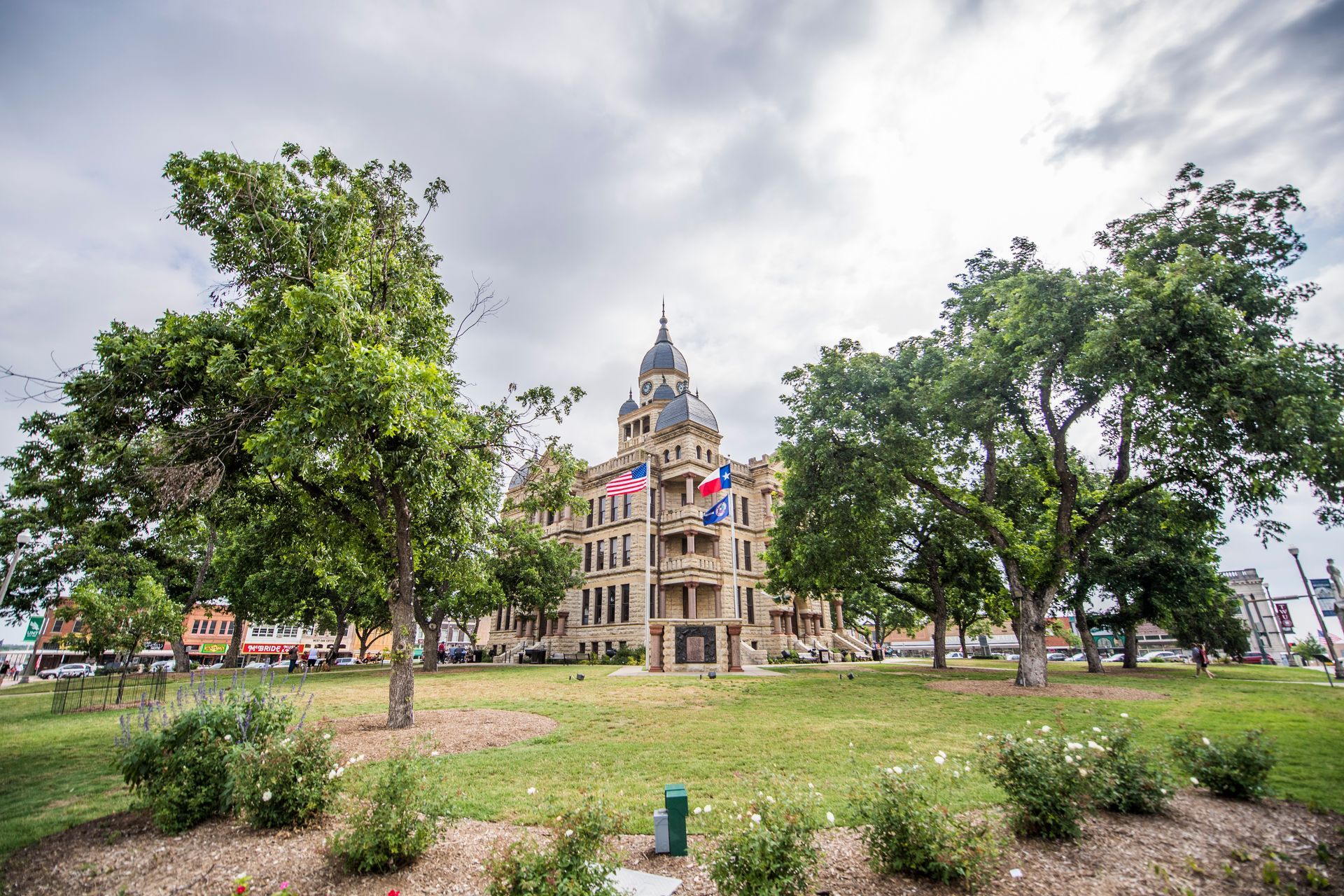 “Downtown Denton Square surrounding Denton County Courthouse with streets and local businesses”