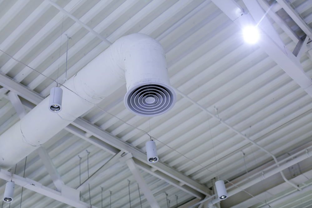 A White Air Duct Is Hanging from The Ceiling of A Building — Danzair Refrigeration & Airconditioning in South Lismore, NSW