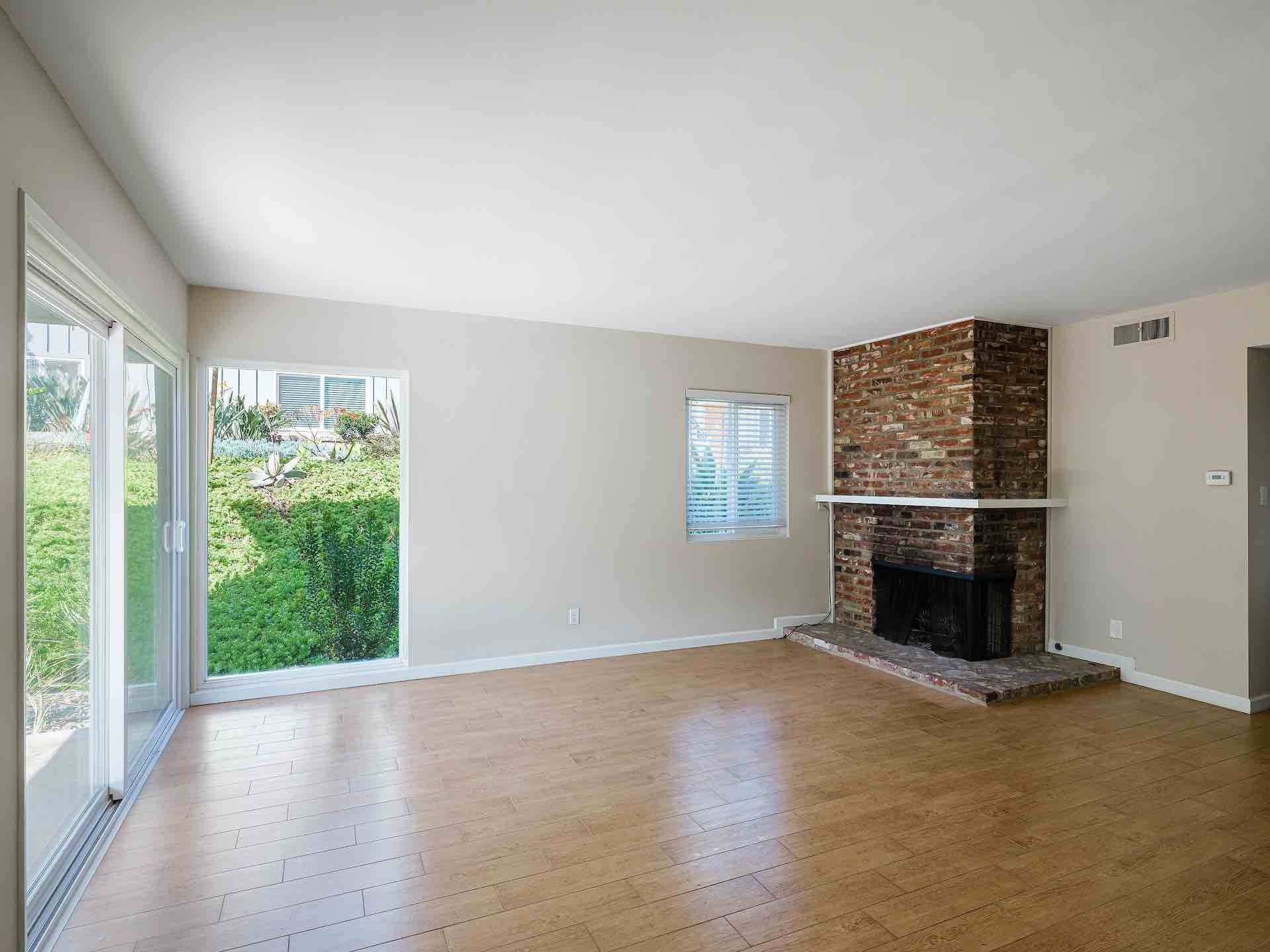 Living room with hardwood floors and a brick fireplace