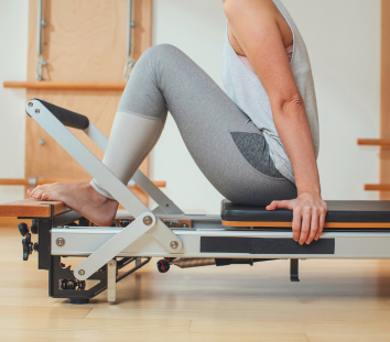 An image of an individual practicing Pilates with professional Pilates equipment.