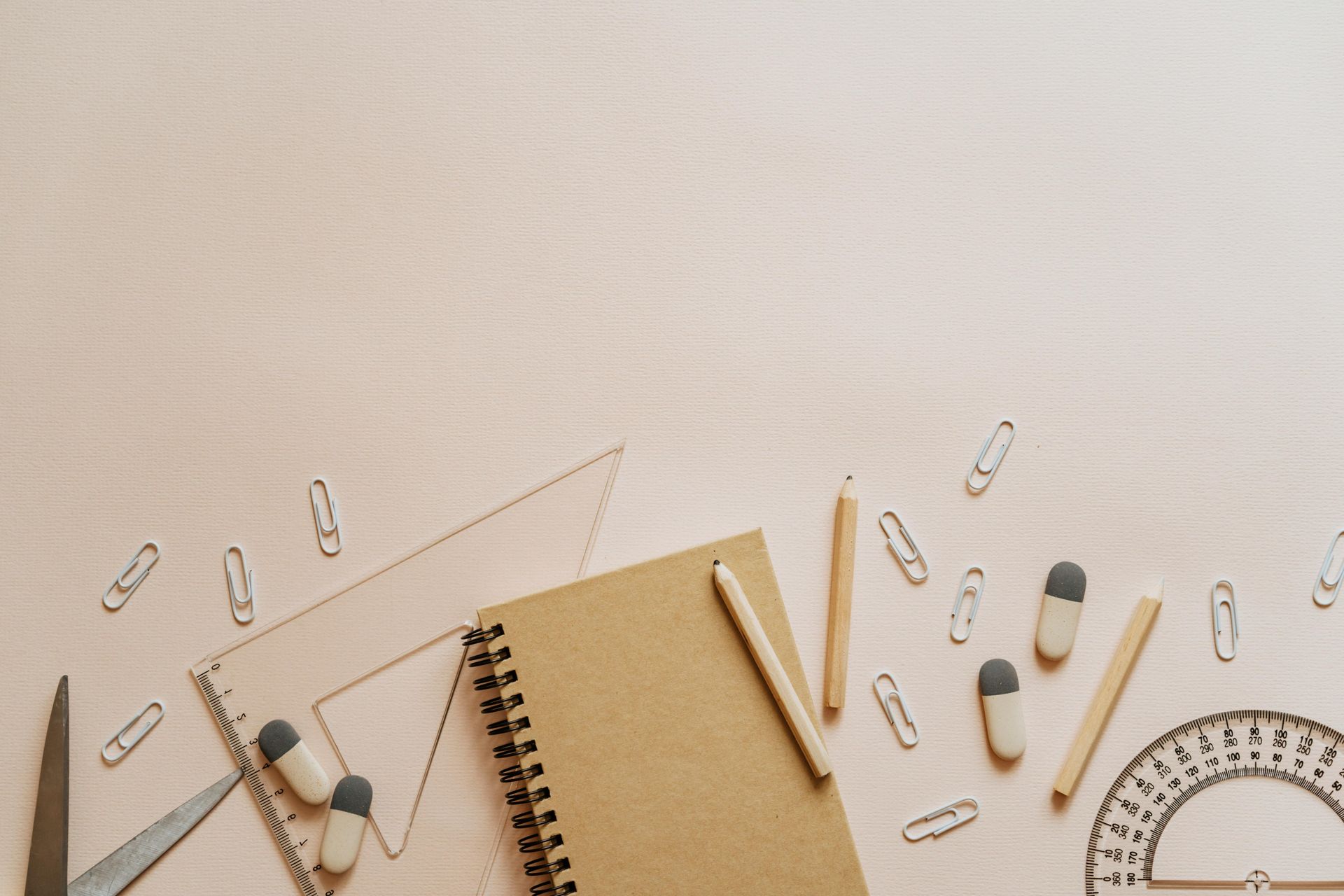 The image shows a back to school scene, with notebooks, paperclips, andwith supplie