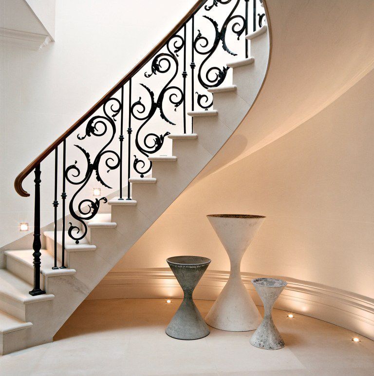 a curved staircase with a wrought iron railing