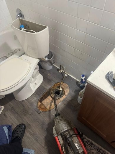 A toilet is being installed in a bathroom with a snake in it.