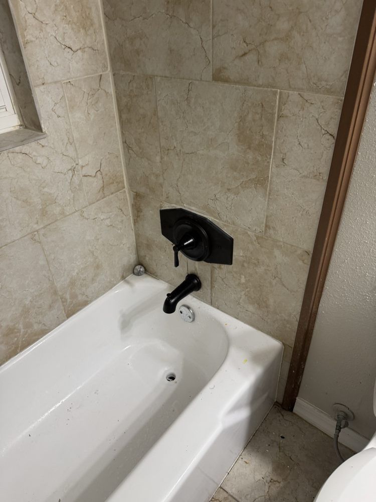 A bathtub in a bathroom next to a toilet.