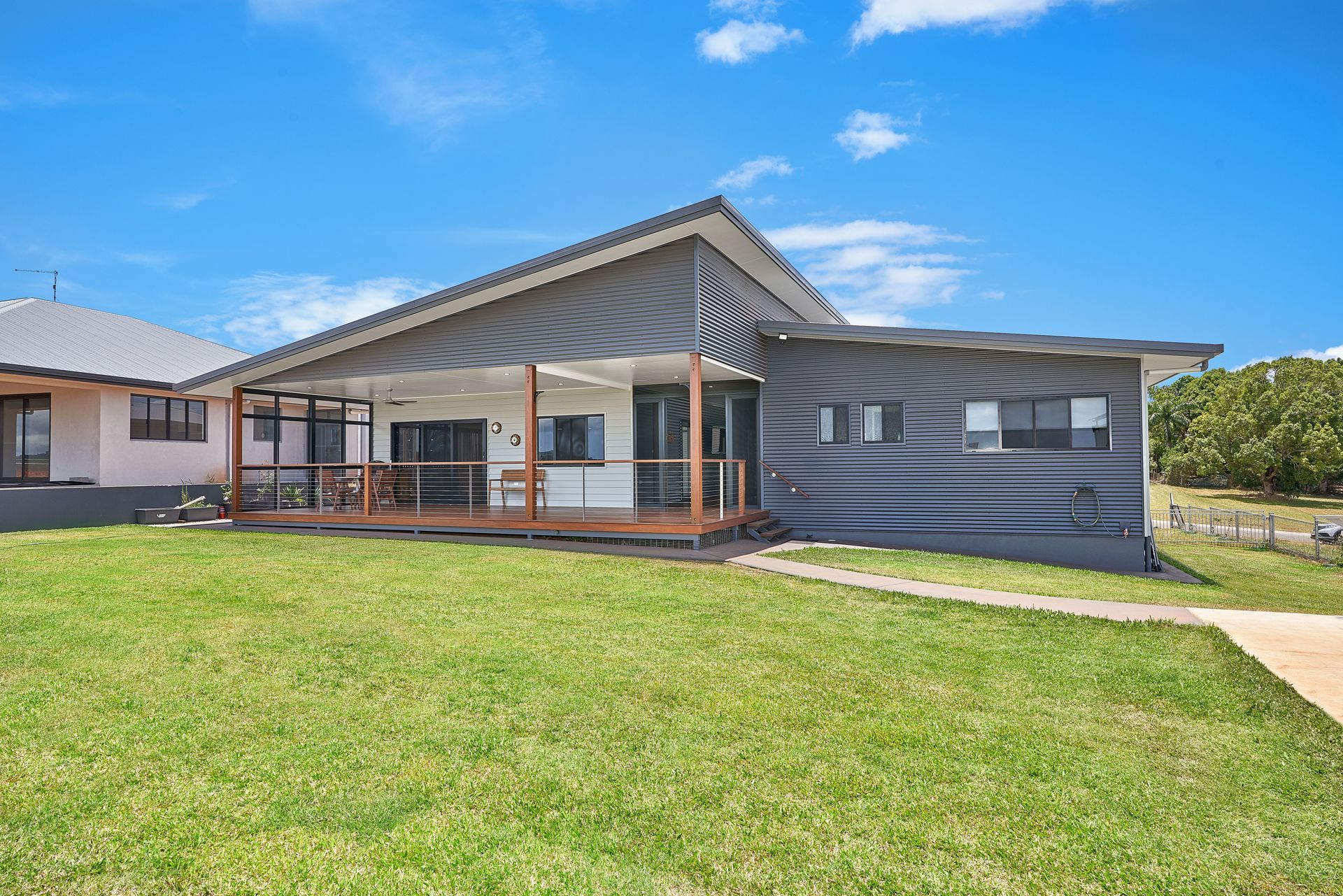 A Kitchen With White Cabinets, a Stove Top Oven, and a Hood — ROGA Build Solutions in Atherton, QLD