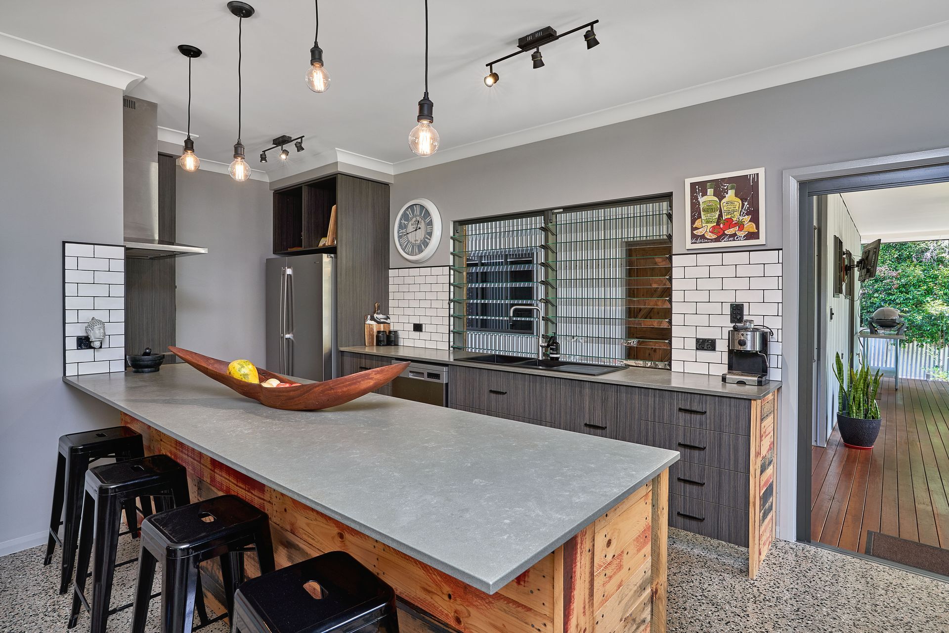 A Kitchen With An Island Bench And Hanging Lights — ROGA Build Solutions in Atherton, QLD