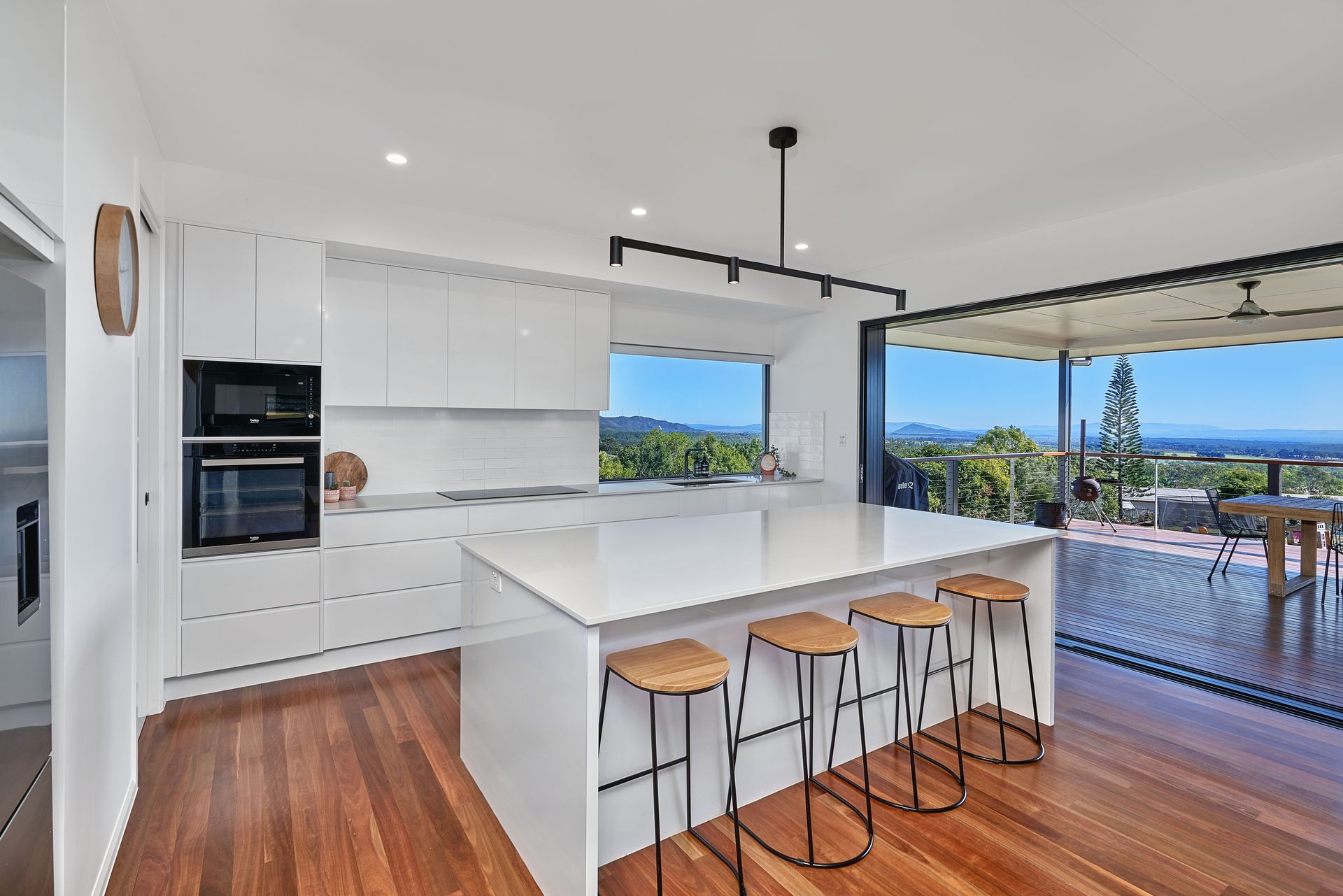 A Kitchen With An Island Bench And Stools — ROGA Build Solutions in Atherton, QLD