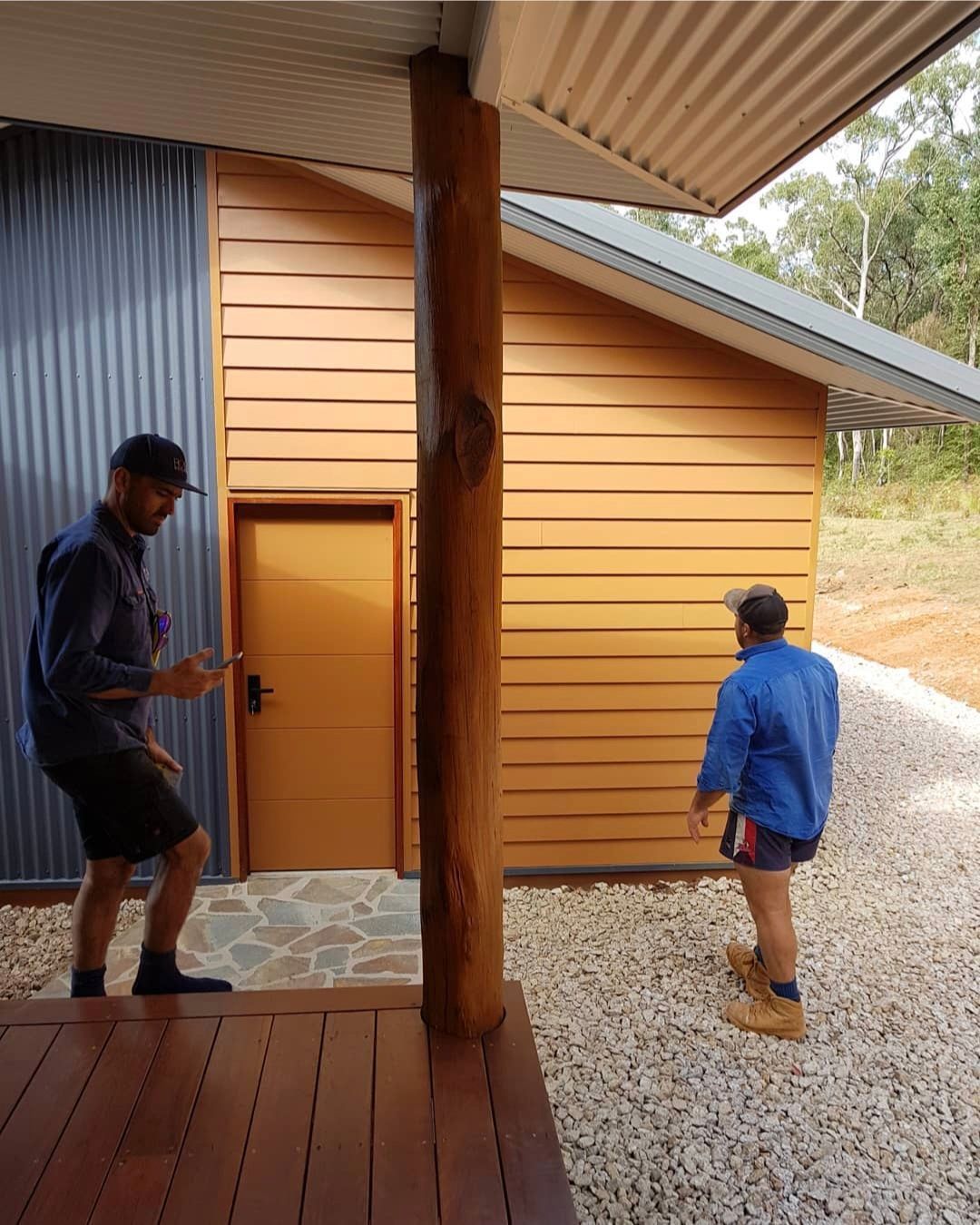Two Men Are Standing Next To A Wooden Deck — ROGA Build Solutions in Atherton, QLD