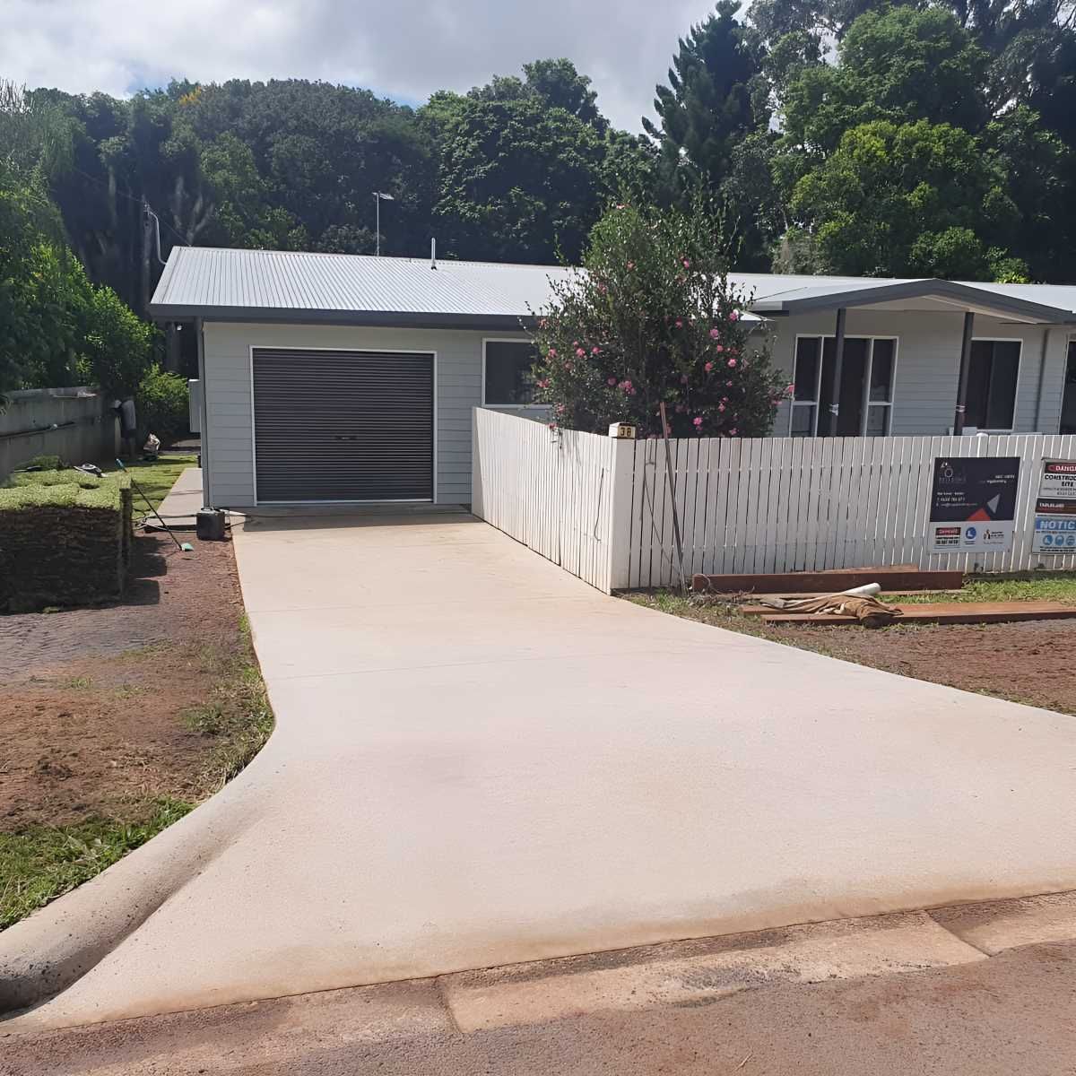 A Driveway Leading to a House With a White Fence— ROGA Build Solutions in Mareeba, QLD