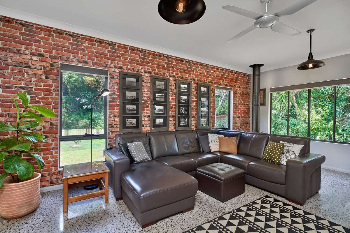 A Living Room With a Large Sectional Couch and a Ceiling Fan — ROGA Build Solutions in Mareeba, QLD