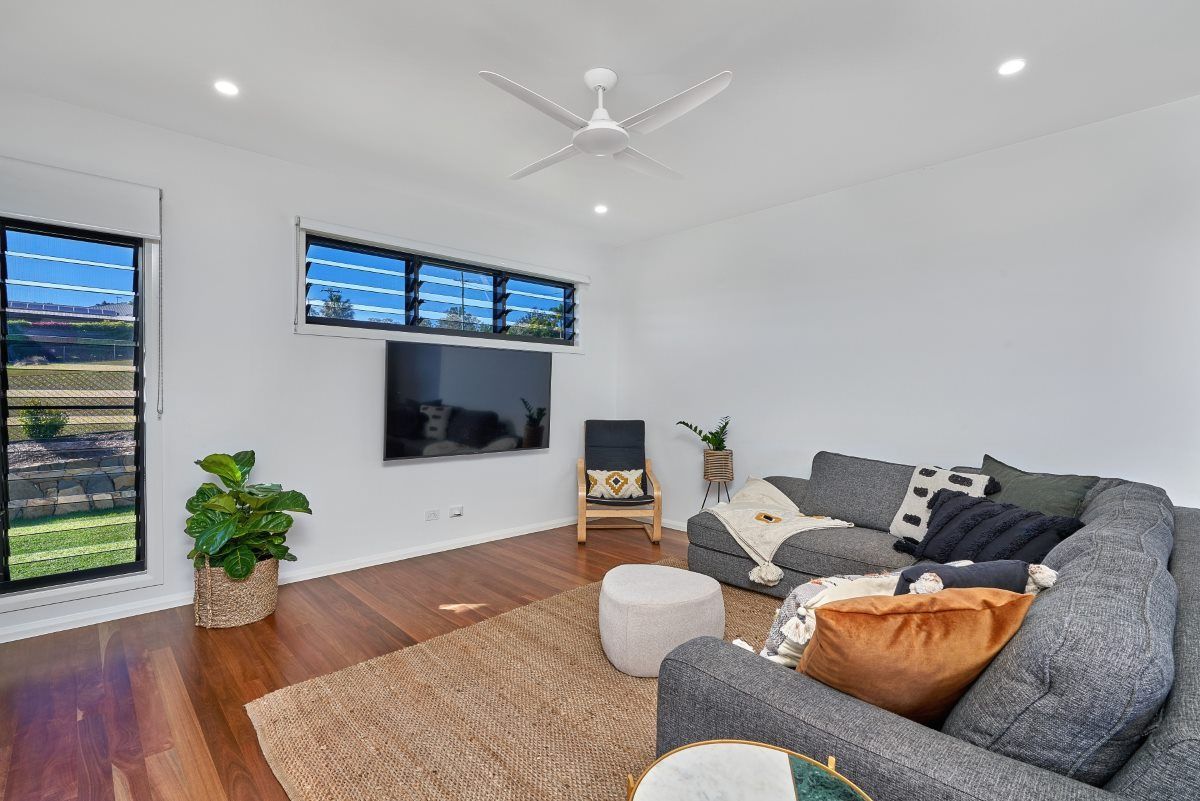 A Living Room With A Grey Couch And TV — ROGA Build Solutions in Atherton, QLD