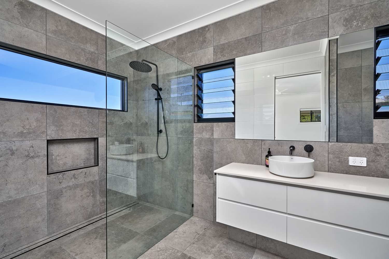 A Bathroom With a Walk in Shower, Sink, Mirror and Window — ROGA Build Solutions in Atherton, QLD