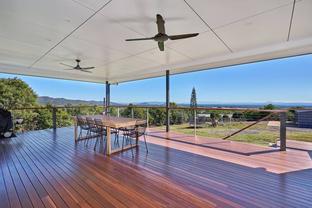 A Wooden Deck With A Table And A Ceiling Fan — ROGA Build Solutions in Atherton, QLD