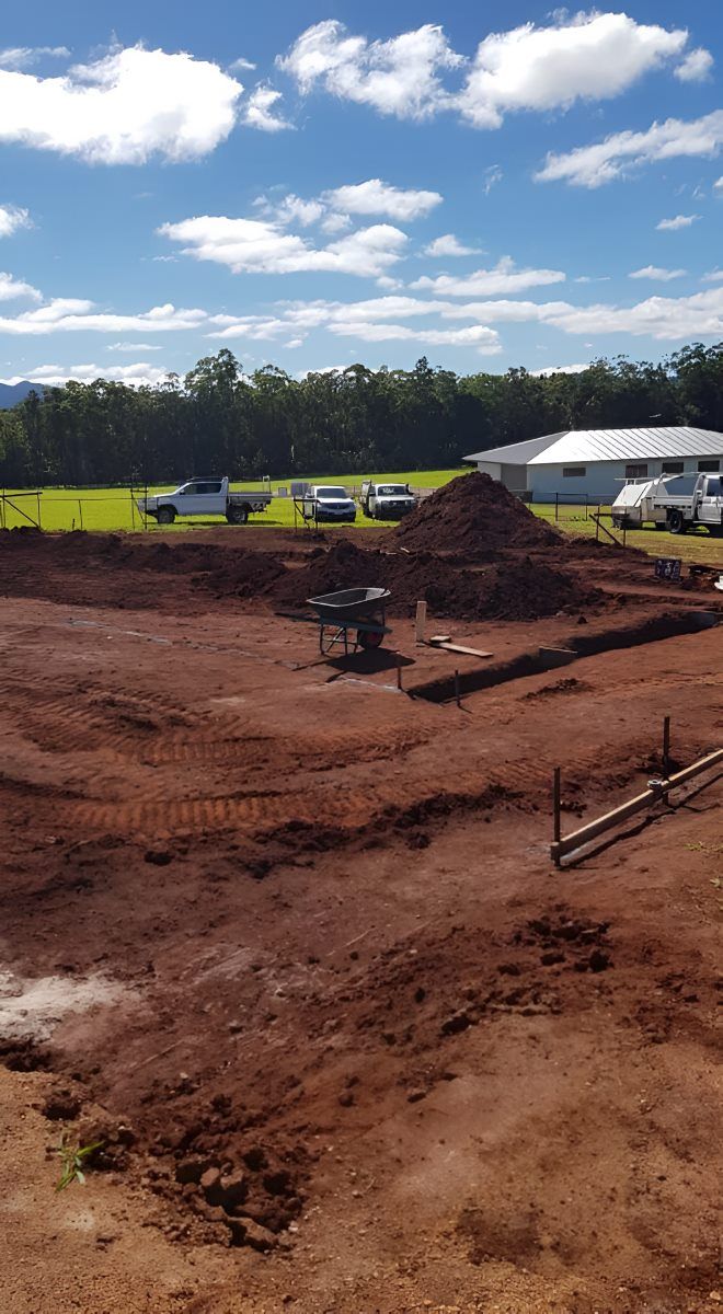 A Large Pile of Dirt is Sitting on Top of a Dirt Field — ROGA Build Solutions in Atherton, QLD