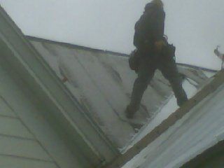 Man Standing on Roof to Repair