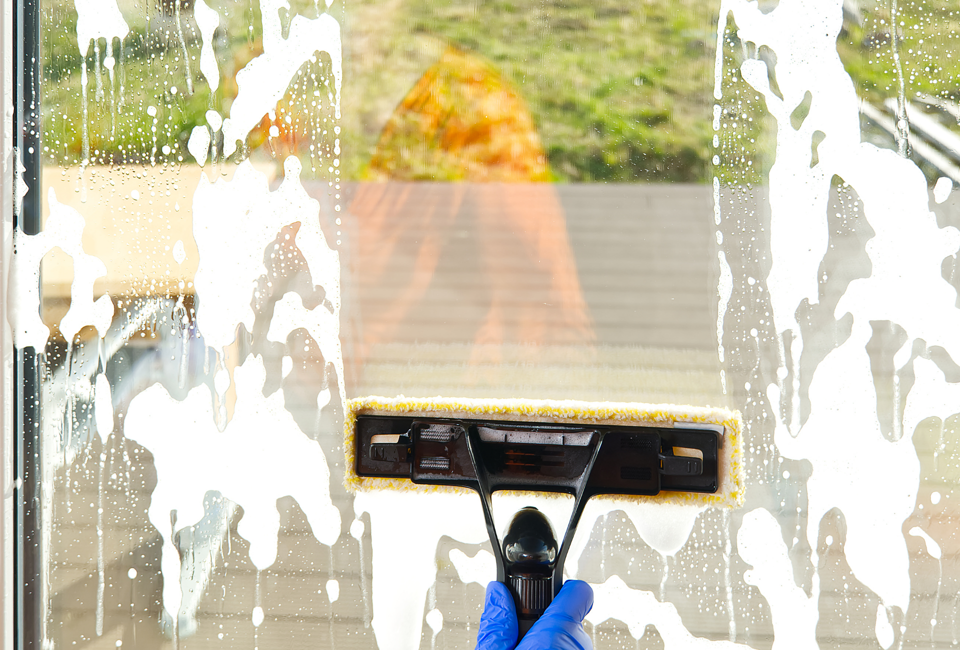 A person is cleaning a window with a squeegee.