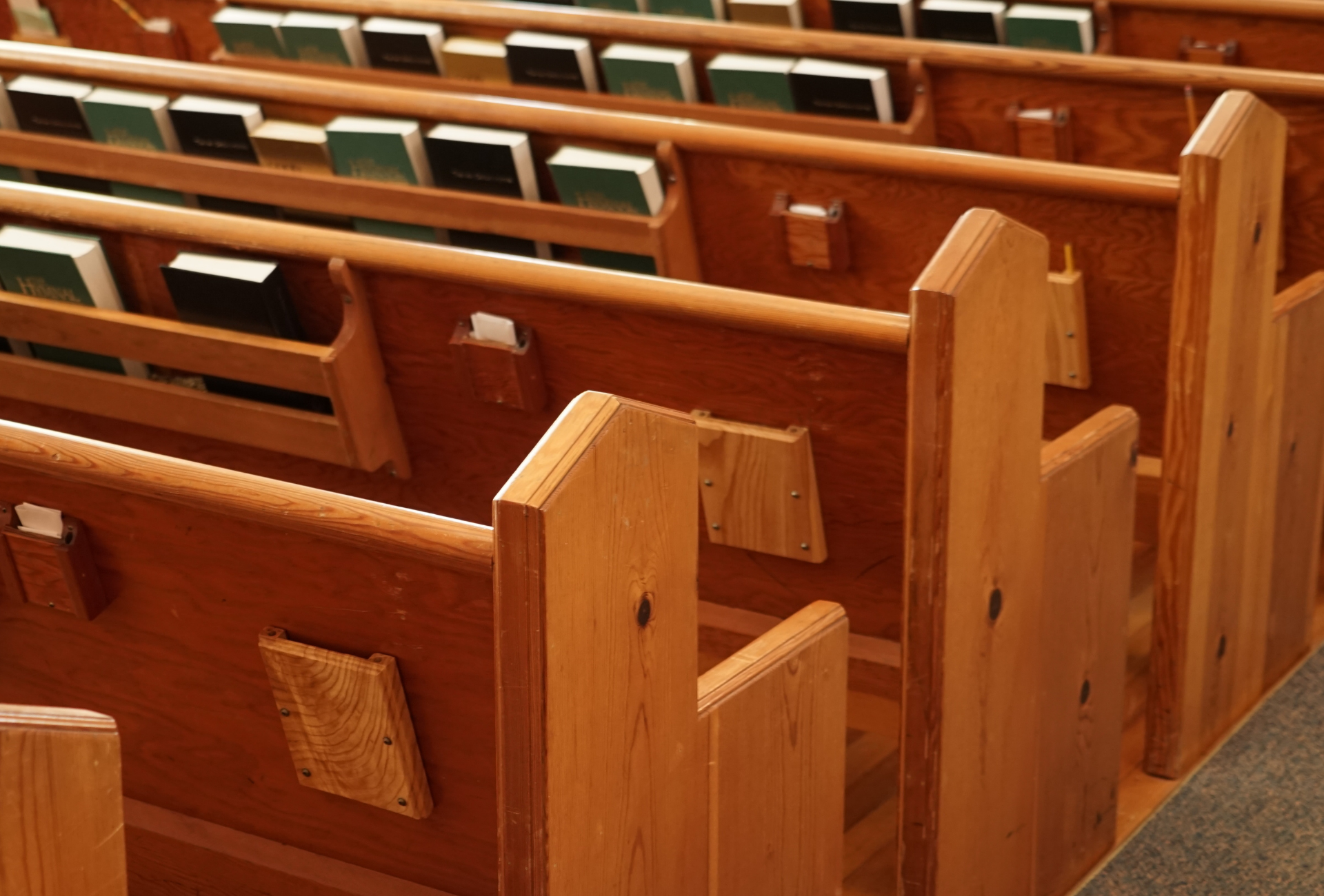 A person is cleaning a couch with a vacuum cleaner.