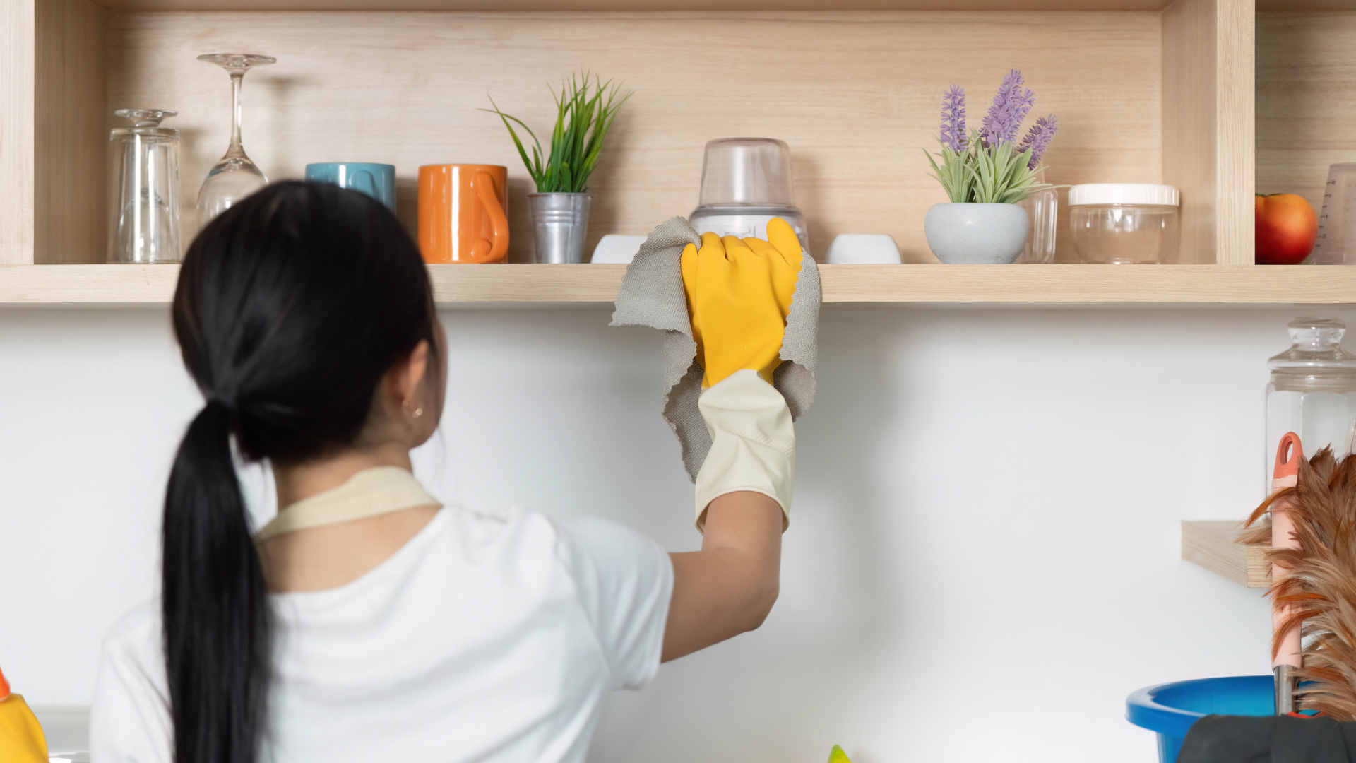 Close-up of a greasy range hood filter being removed for cleaning, illustrating a commonly overlooked kitchen crevice.