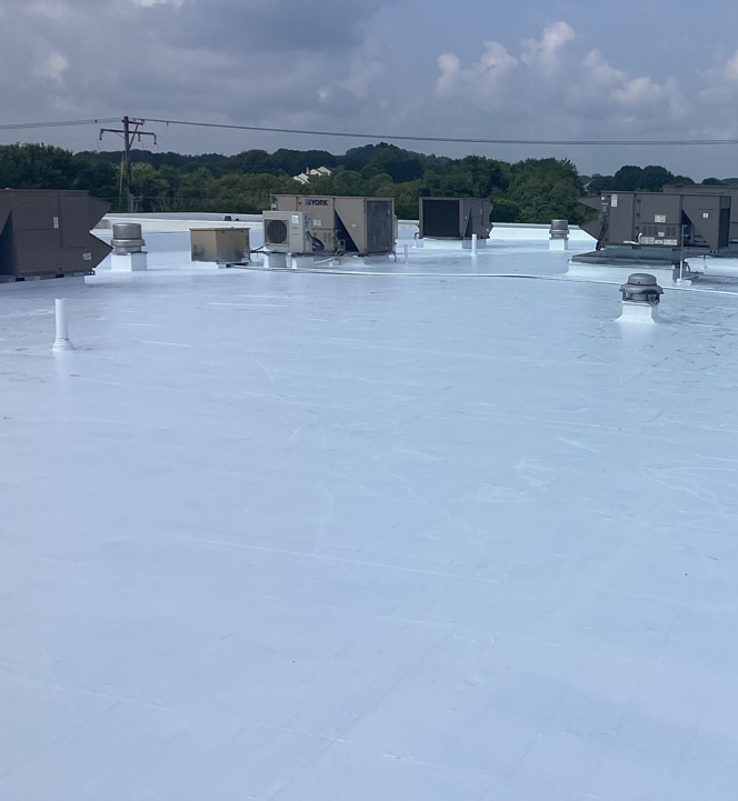 A Man Is Standing On Top Of A White Roof — Mohnton, PA — Meadow Springs
