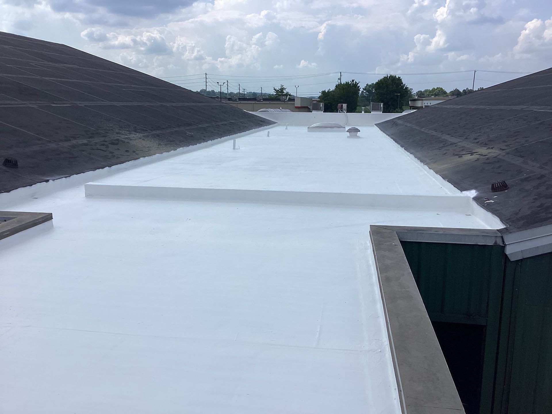 Two Construction Workers Are Working On The Roof Of A Building — Mohnton, PA — Meadow Springs