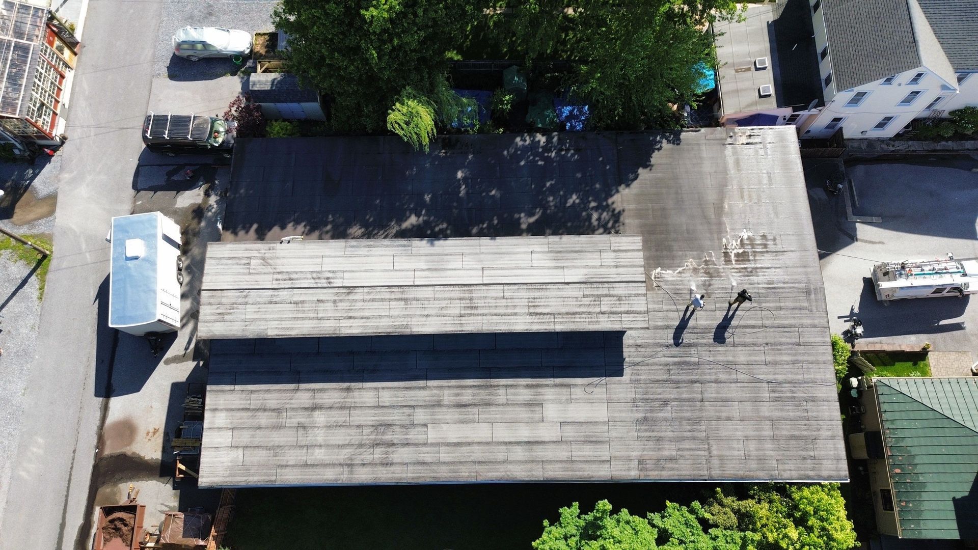 White corrugated metal roof with construction equipment in background.