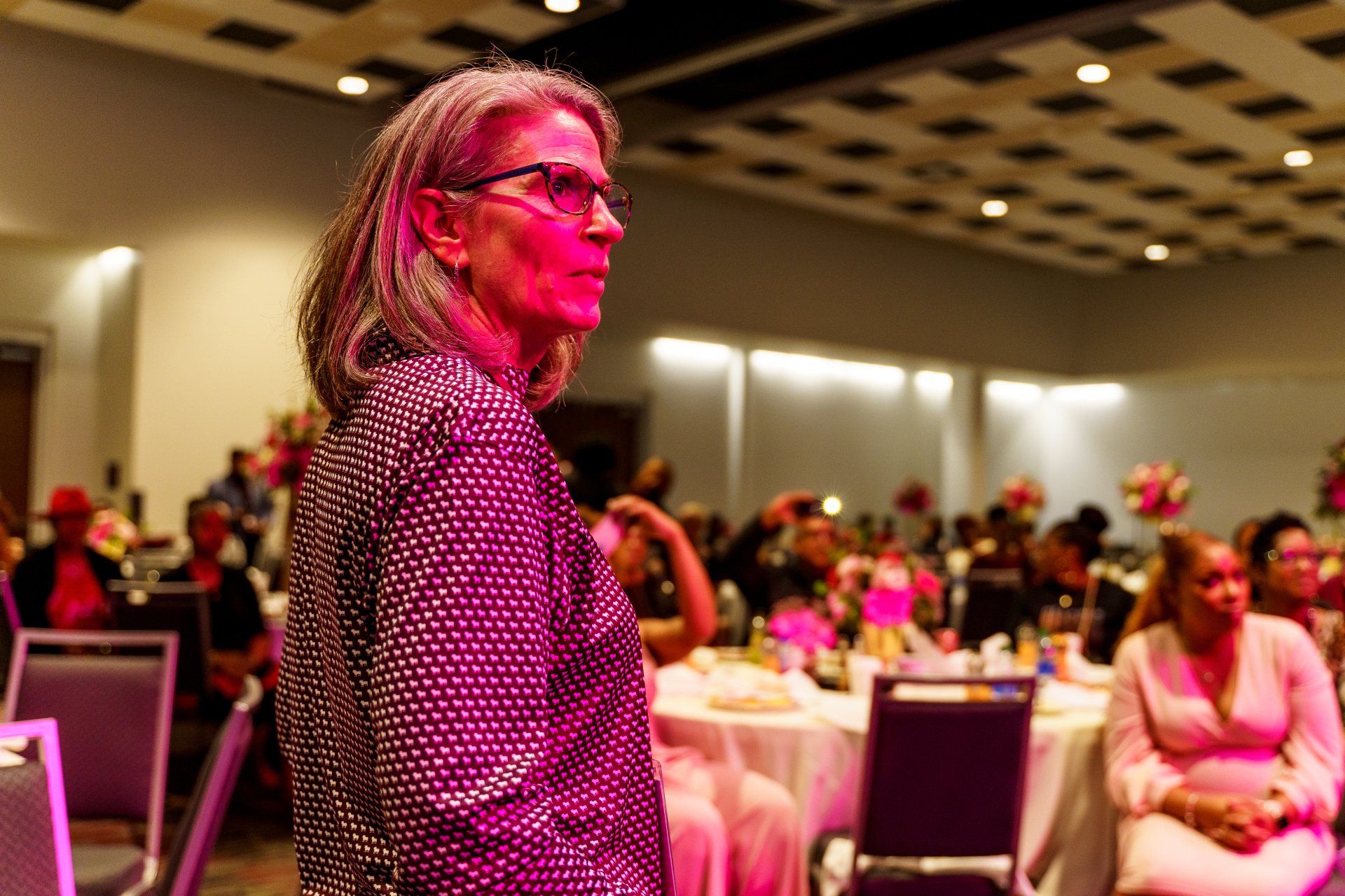 a woman is standing in front of a crowd of people in a room .