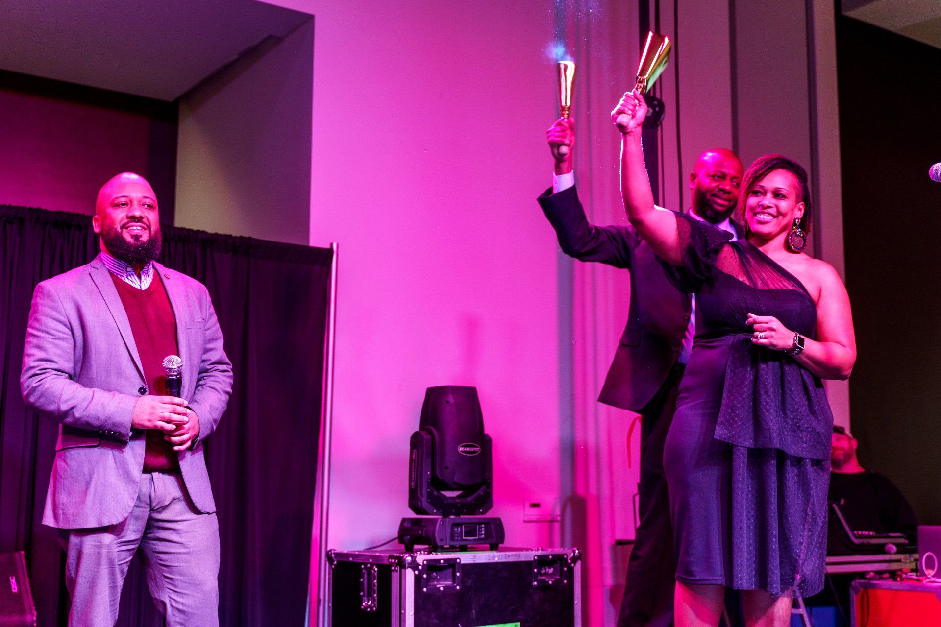 a group of people are standing on a stage holding a torch .