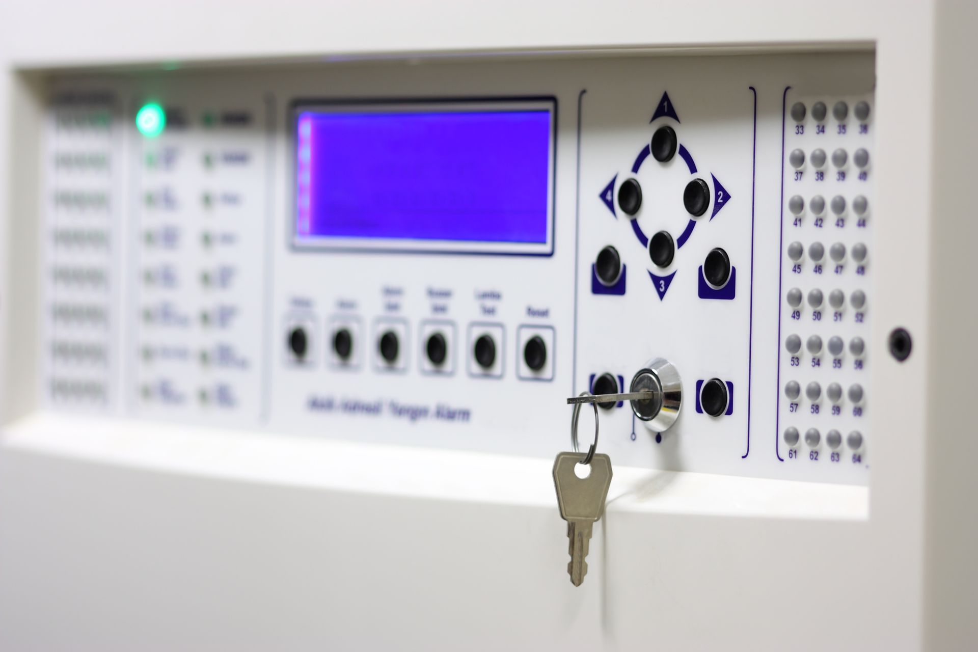 Alarm security keypad system on a wall in an industrial location.