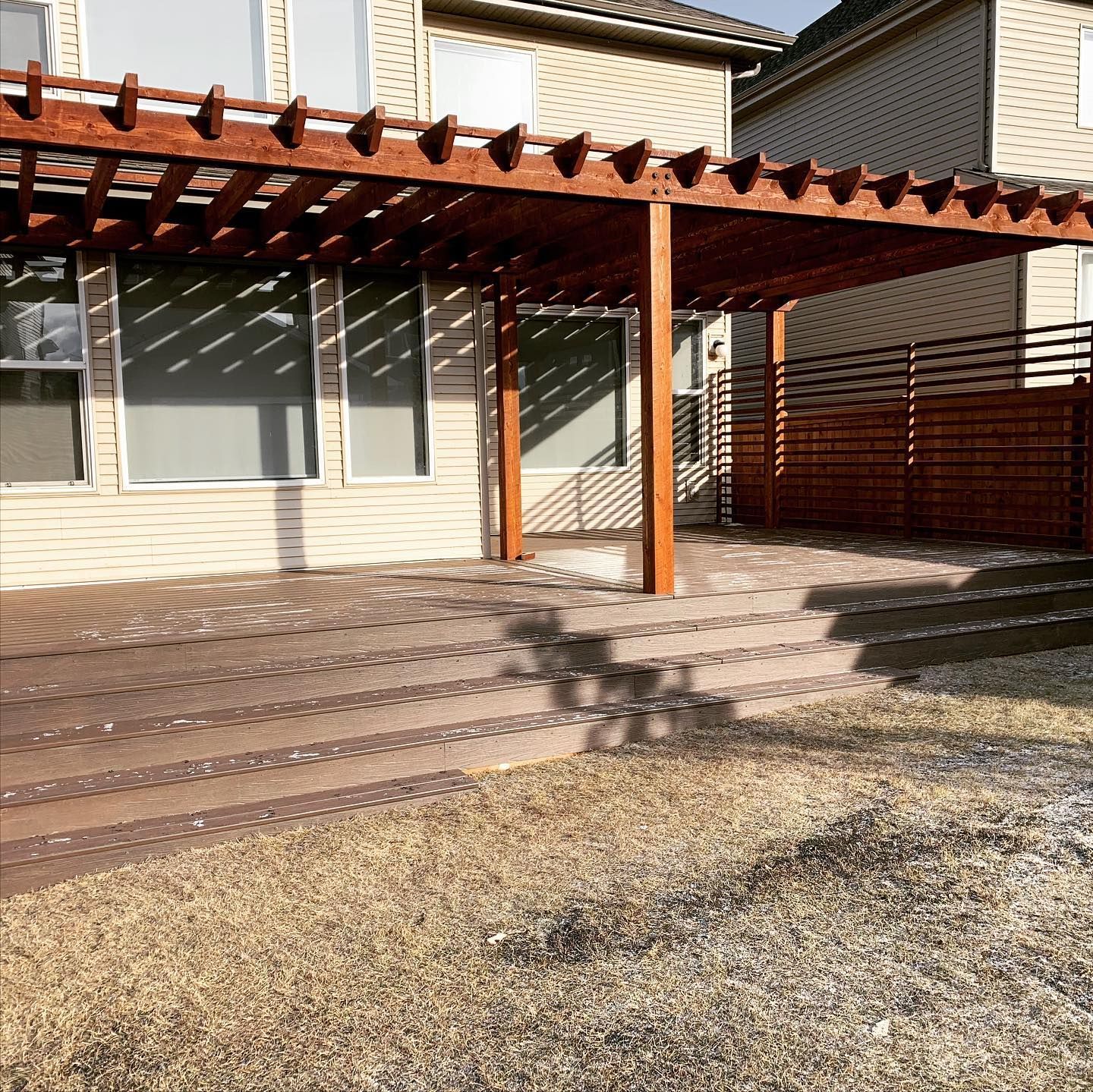 A house with a pergola and stairs in front of it