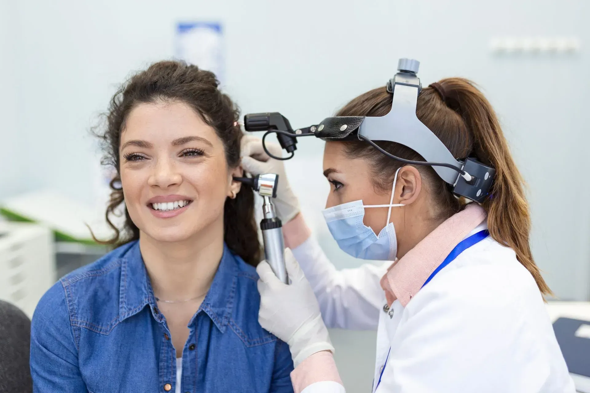 A woman is getting her ears examined by an otolaryngologist.