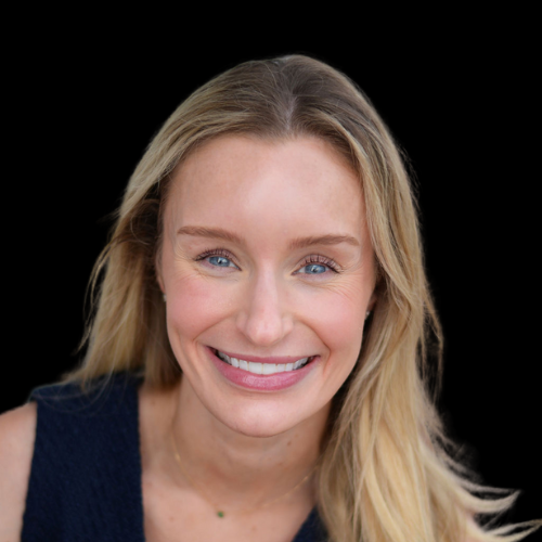 A woman with blonde hair and blue eyes is smiling for the camera