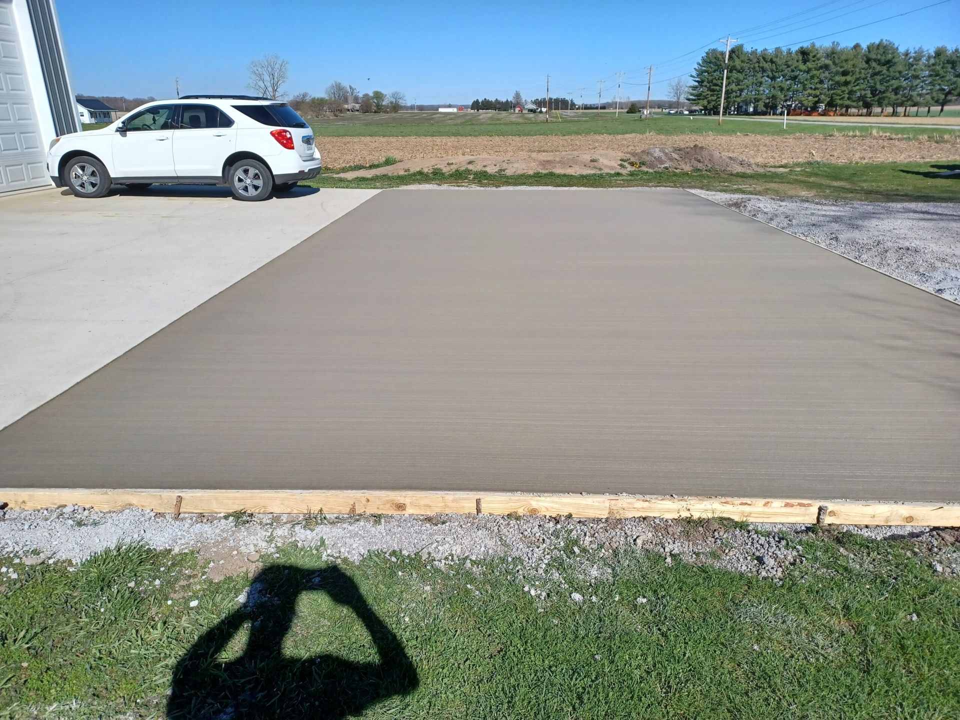 A white suv is parked in a concrete driveway.