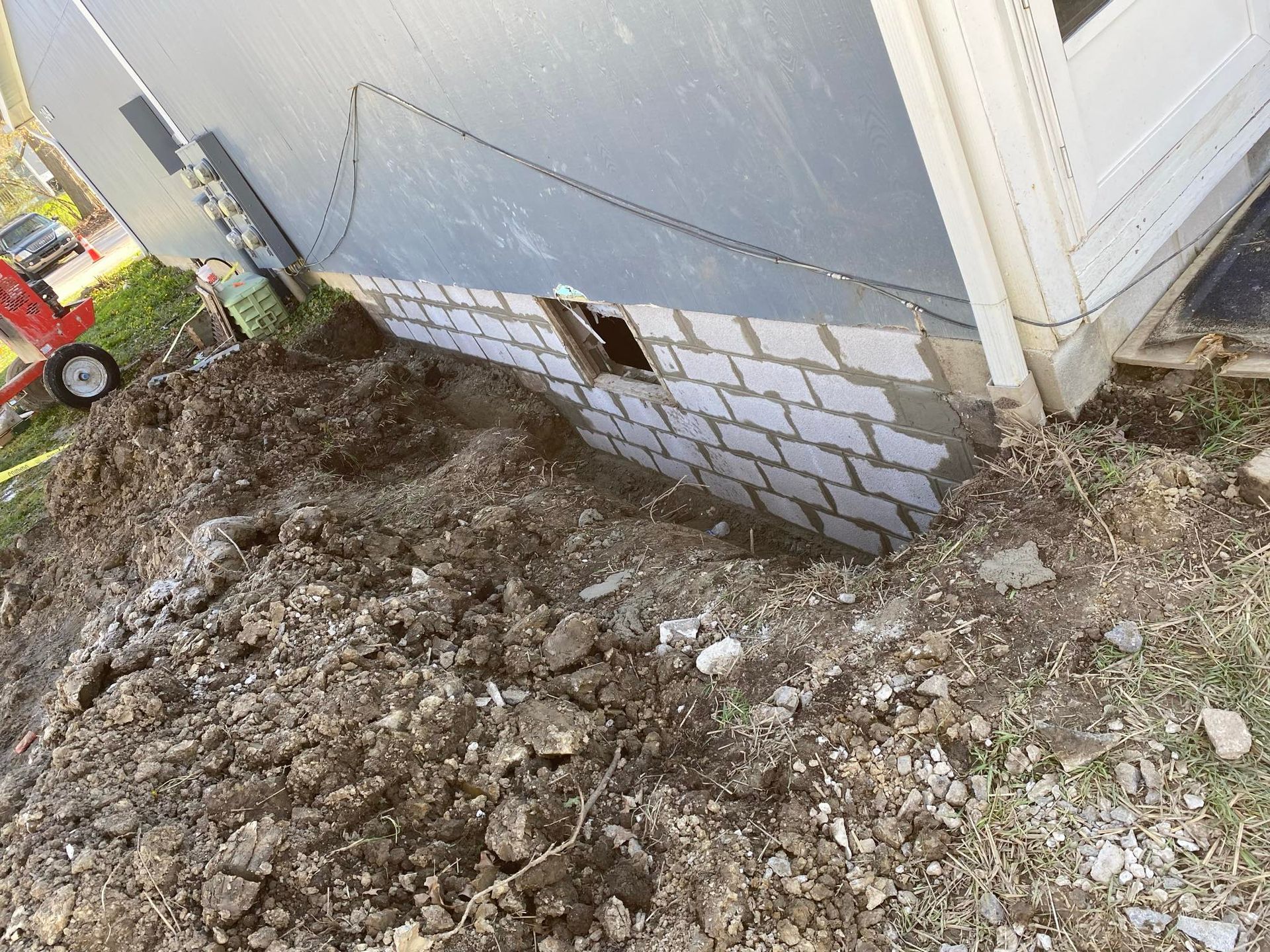 A brick wall is being built on the side of a house.